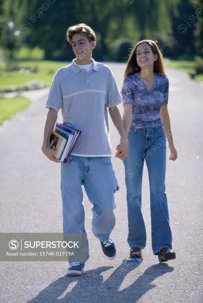 Stock Photo: 1574R-01979A Teenage couple holding hands walking outdoors