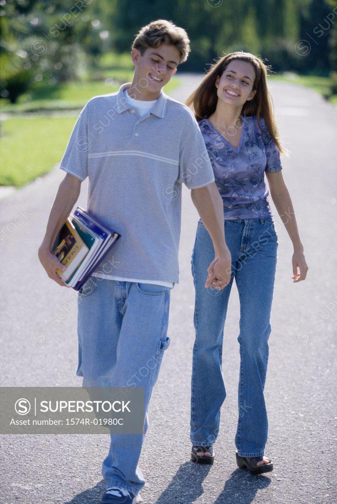 Stock Photo: 1574R-01980C Teenage couple holding hands walking outdoors