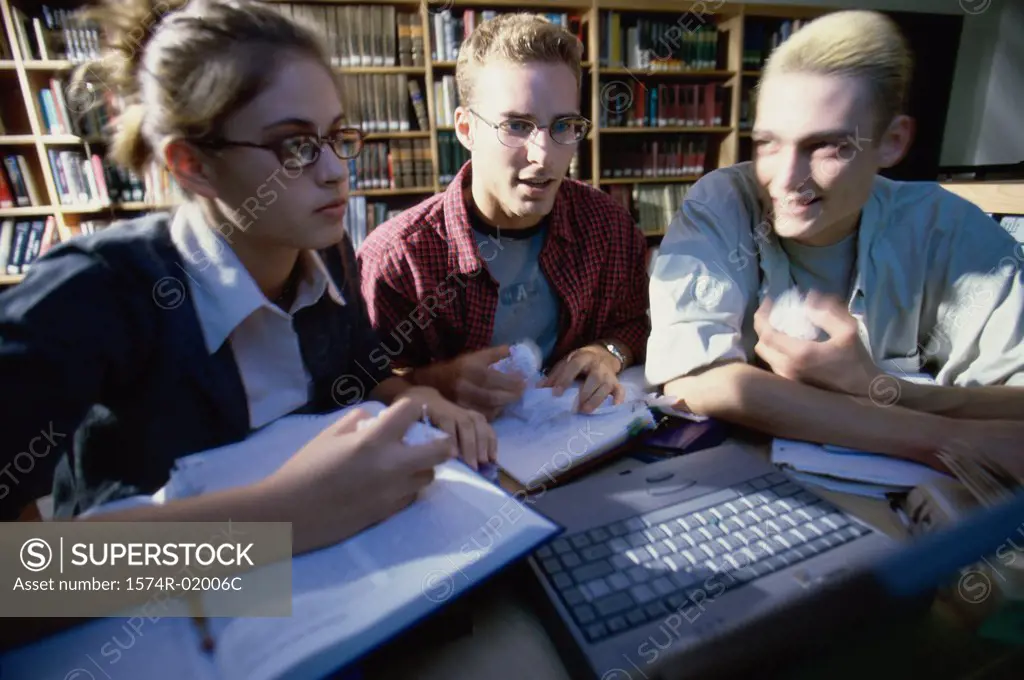 Close-up of three teenage students studying in a library