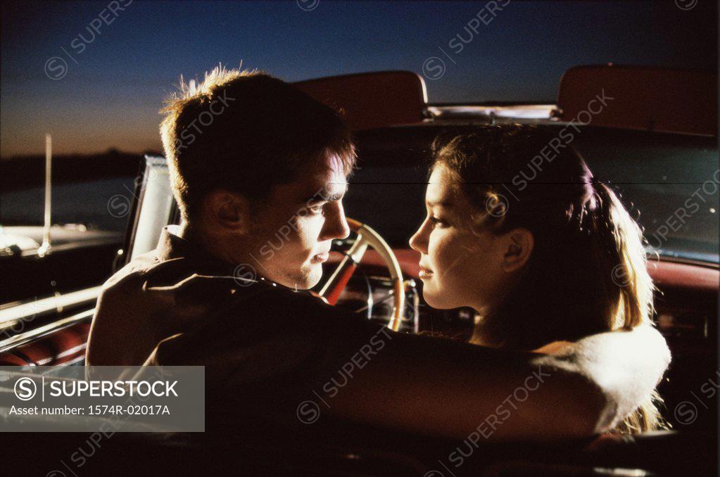 Stock Photo: 1574R-02017A Rear view of a young couple sitting in a convertible car