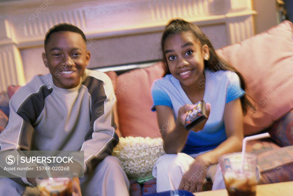 Stock Photo: 1574R-02026B Teenage boy and girl sitting on a couch and watching television
