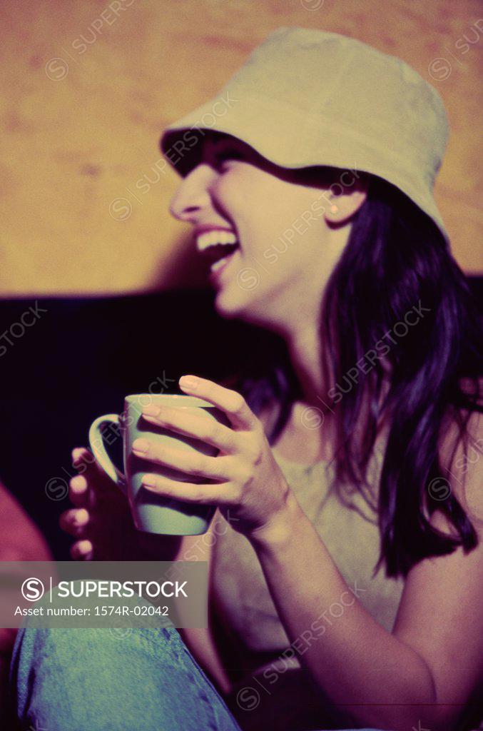 Stock Photo: 1574R-02042 Young woman drinking a cup of coffee