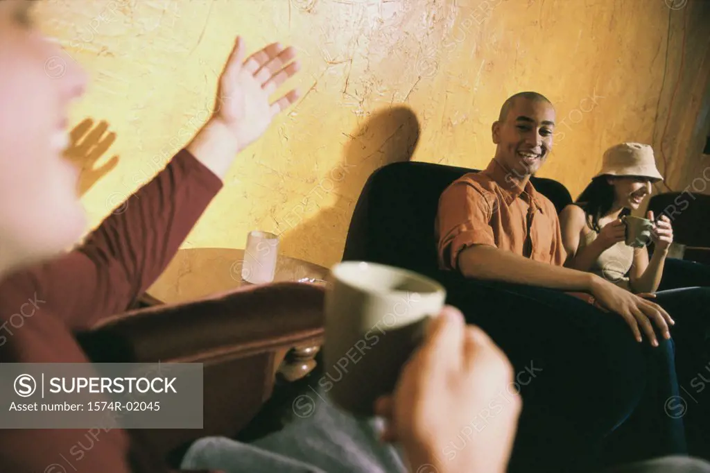Close-up of a young man talking to friends in a living room