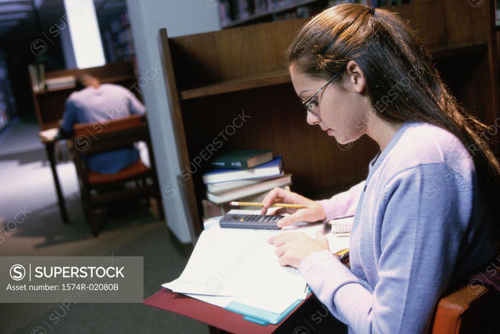 Stock Photo: 1574R-02080B Teenage girl studying in a library