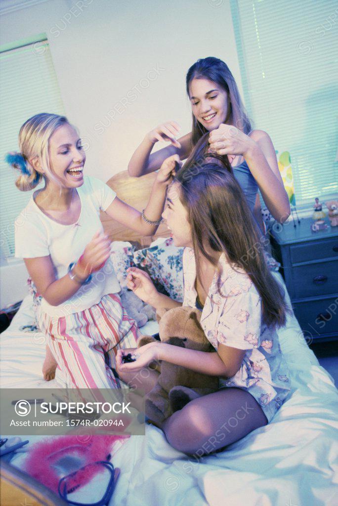 Stock Photo: 1574R-02094A Three teenager girls making hairstyles