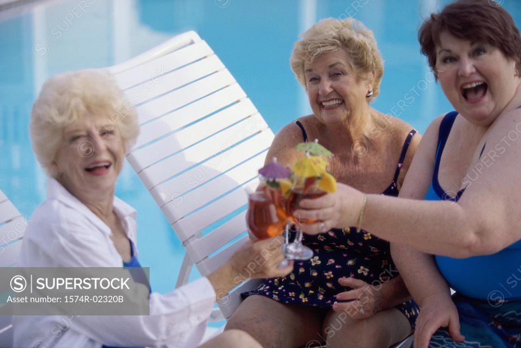 Stock Photo: 1574R-02320B Portrait of three senior women toasting glasses of red wine