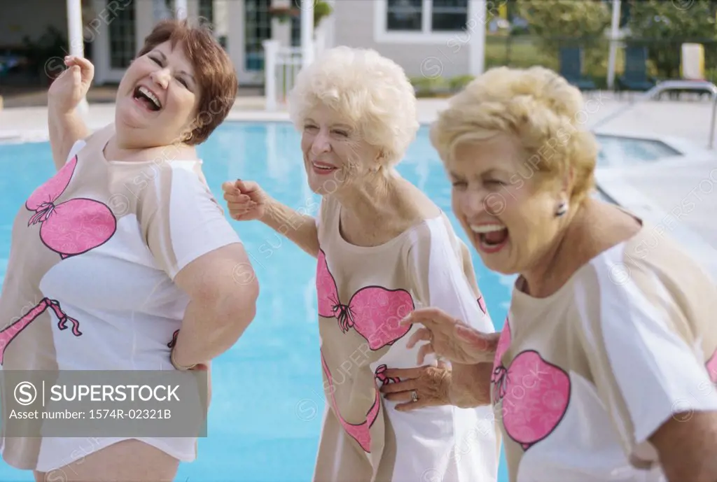 Three senior women standing near a swimming pool