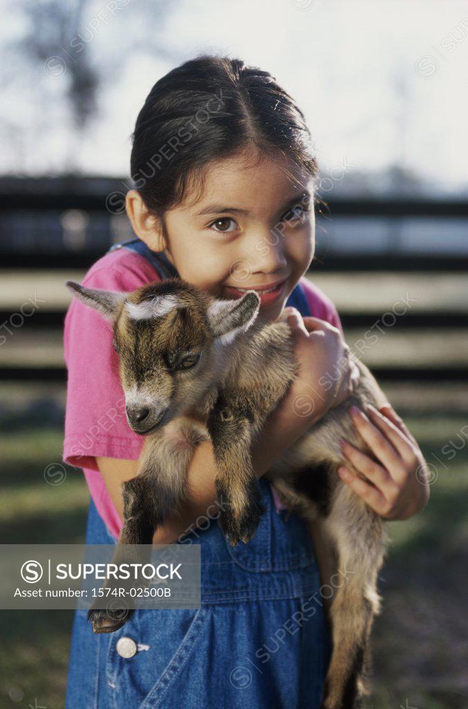 Stock Photo: 1574R-02500B Portrait of a girl holding a kid goat in her arms