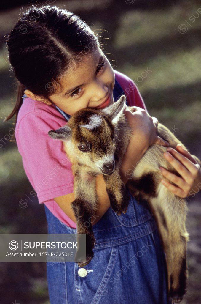 Stock Photo: 1574R-02501E High angle view of a girl holding a kid goat in her arms