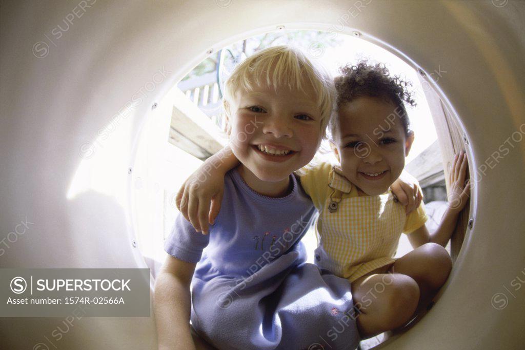 Stock Photo: 1574R-02566A Portrait of two girls playing in a tube
