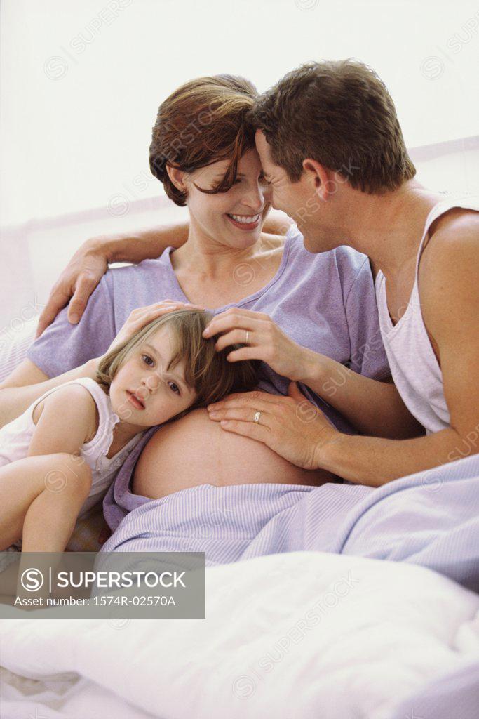 Stock Photo: 1574R-02570A Daughter with her head against her pregnant mother's abdomen