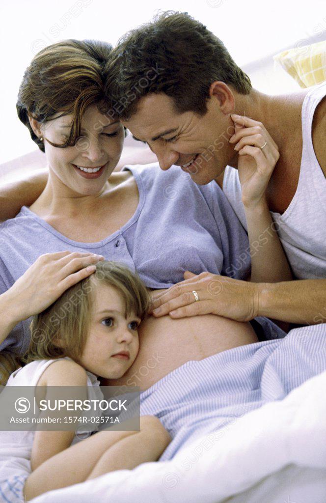 Stock Photo: 1574R-02571A Daughter with her head against her pregnant mother's abdomen