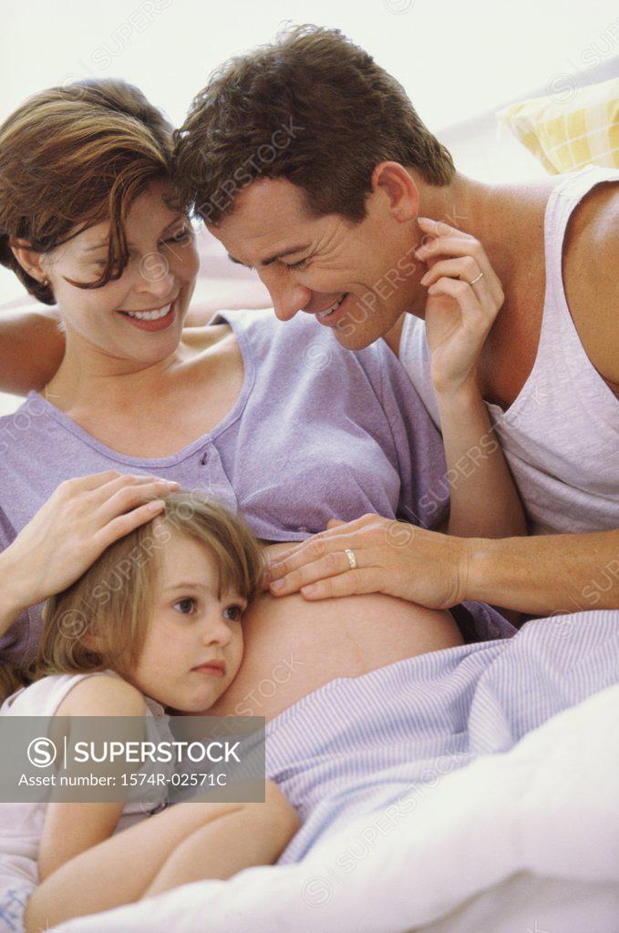 Stock Photo: 1574R-02571C Daughter with her head against her pregnant mother's abdomen