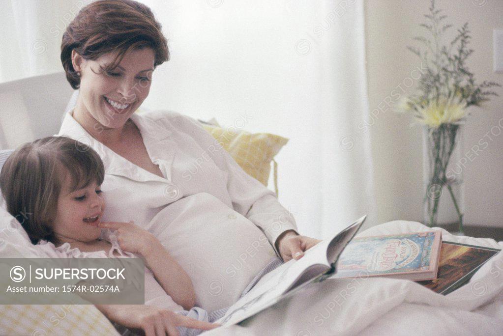 Stock Photo: 1574R-02574A Pregnant woman teaching her daughter