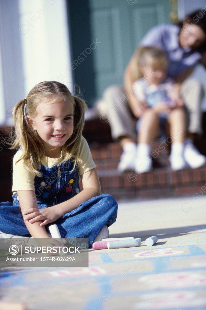 Stock Photo: 1574R-02629A Portrait of a girl drawing on the floor with chalk