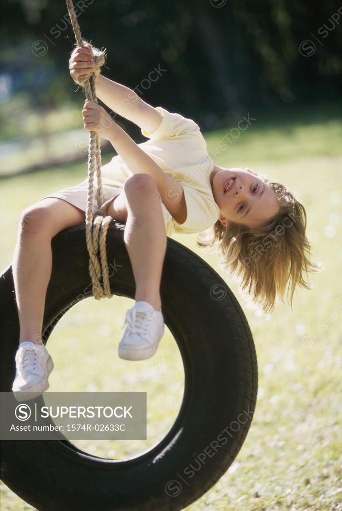 Stock Photo: 1574R-02633C Portrait of a girl sitting on a tire swing