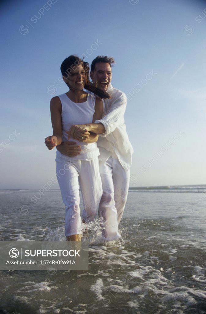 Stock Photo: 1574R-02691A Young couple holding each other on the beach