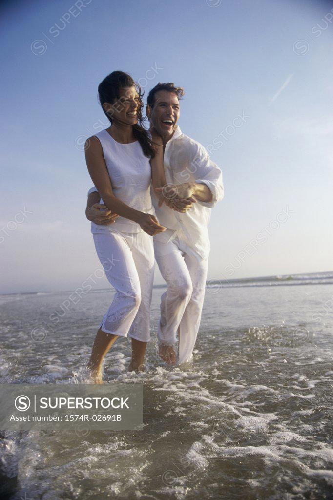 Stock Photo: 1574R-02691B Young couple holding each other on the beach