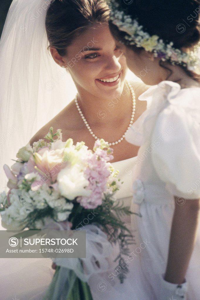 Stock Photo: 1574R-02698D Close-up of a bride smiling at a flower girl