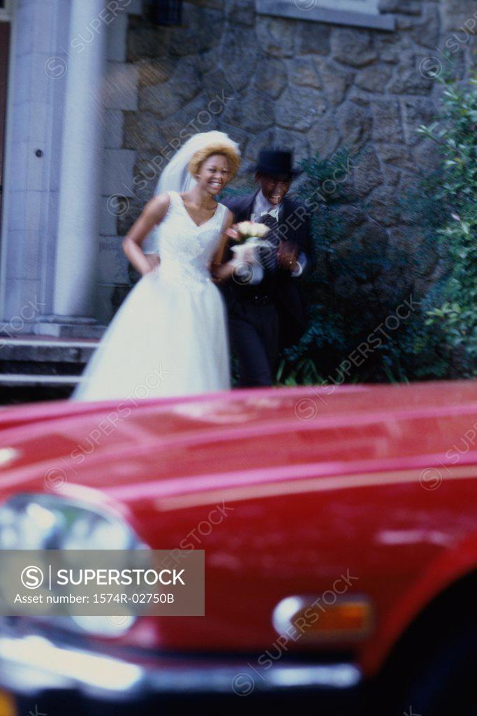 Stock Photo: 1574R-02750B Newlywed couple running towards a car