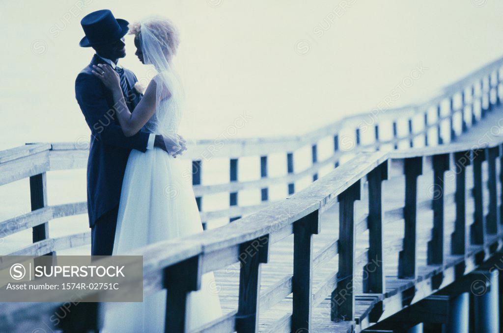 Stock Photo: 1574R-02751C Newlywed couple embracing each other on a pier