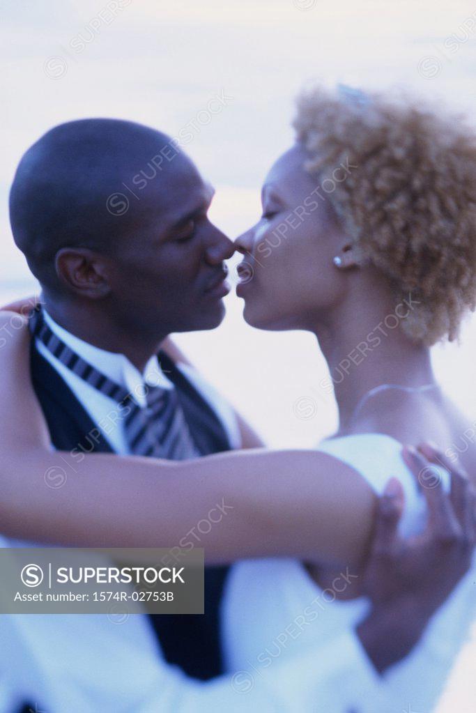 Stock Photo: 1574R-02753B Newlywed couple kissing each other