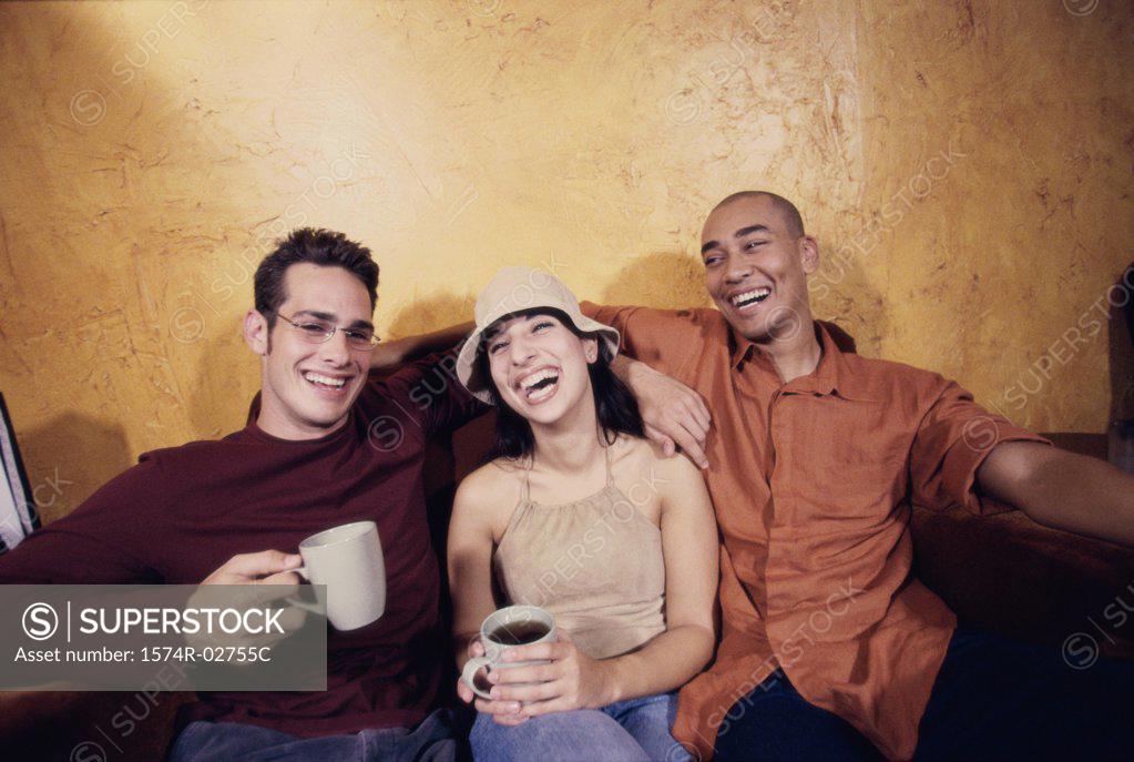 Stock Photo: 1574R-02755C Two young men and a young woman sitting in a cafe drinking coffee