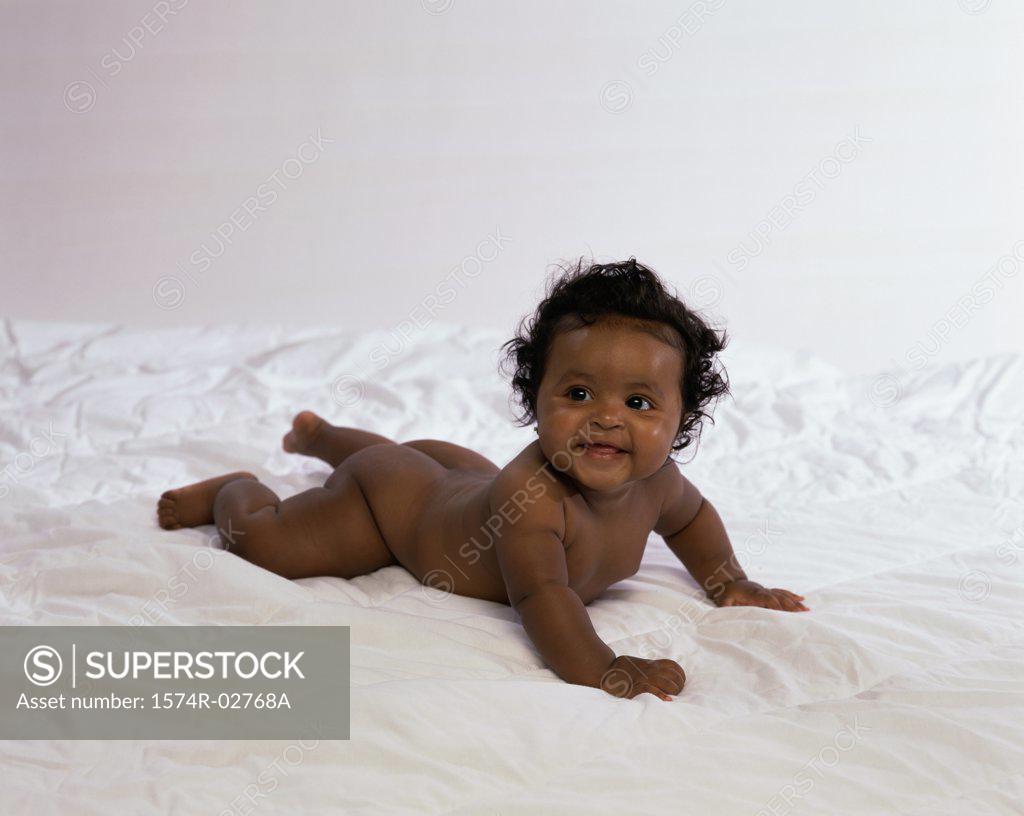 Stock Photo: 1574R-02768A Baby boy lying on a bed and smiling