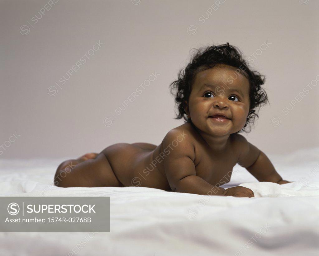 Stock Photo: 1574R-02768B Baby boy lying on a bed and smiling