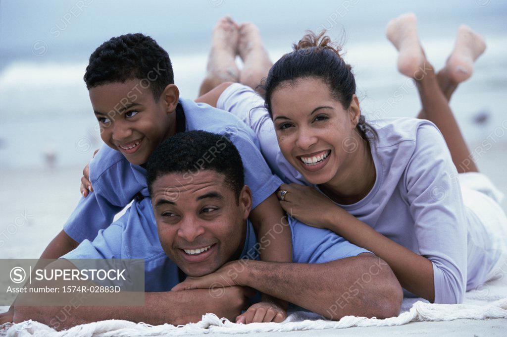 Stock Photo: 1574R-02883D Parents lying with their son on the beach