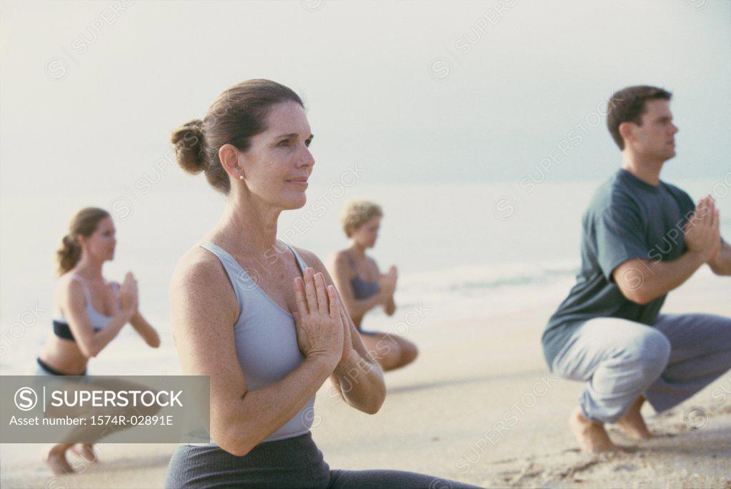 Stock Photo: 1574R-02891E Group of people meditating on the beach