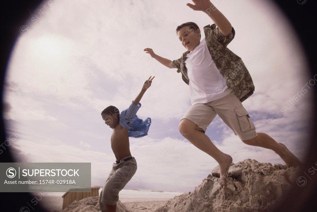 Stock Photo: 1574R-02918A Side profile of two boys jumping on the beach