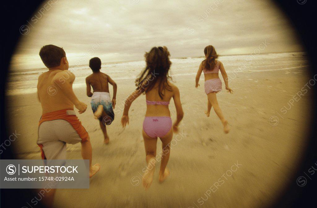 Stock Photo: 1574R-02924A Rear view of a group of children running on the beach