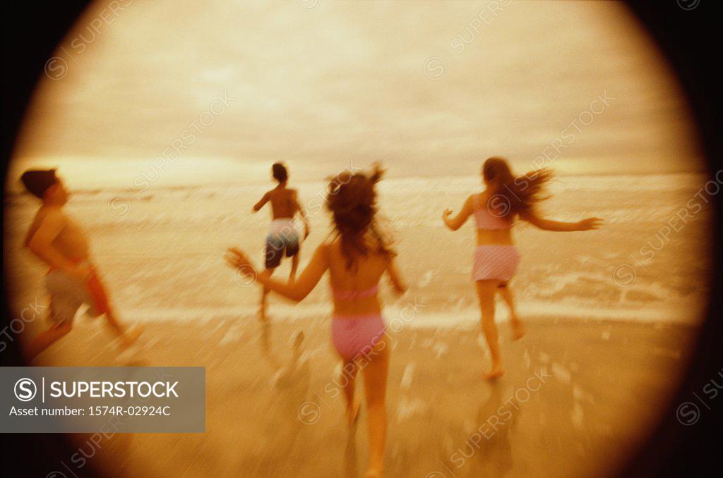 Stock Photo: 1574R-02924C Rear view of a group of children running on the beach