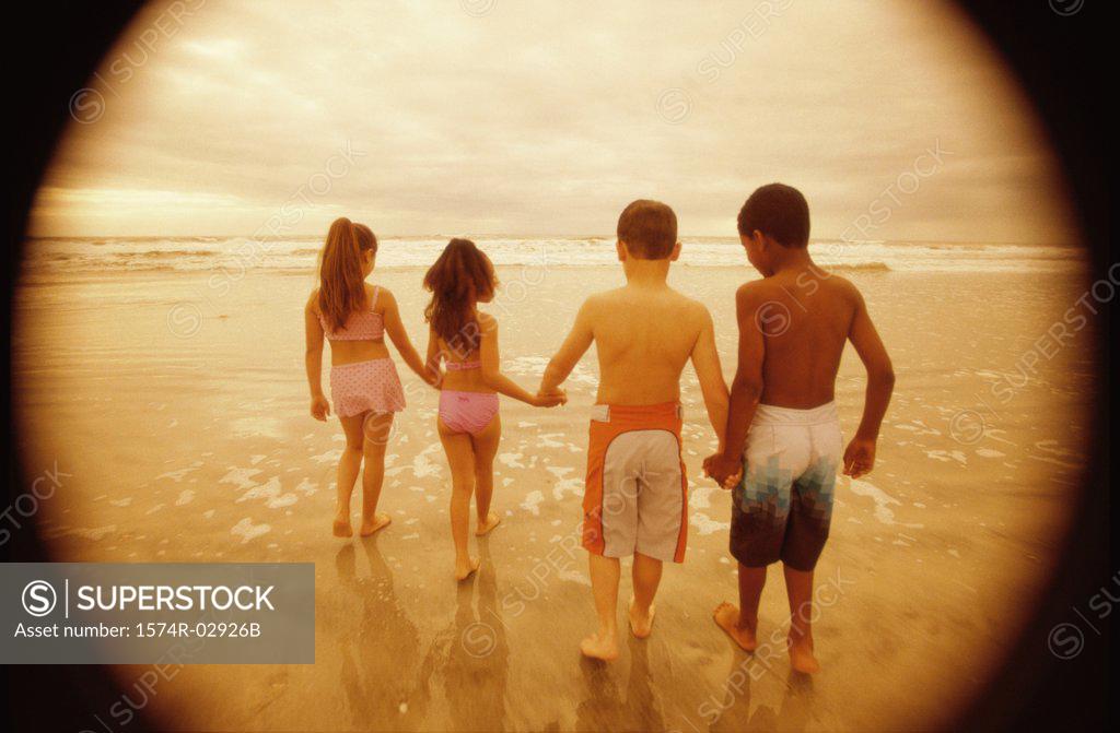 Stock Photo: 1574R-02926B Rear view of a group of children walking on the beach