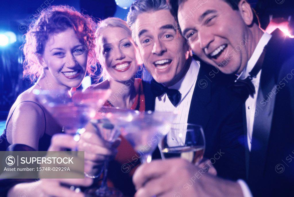Stock Photo: 1574R-02929A Portrait of two mid adult couples toasting at a party