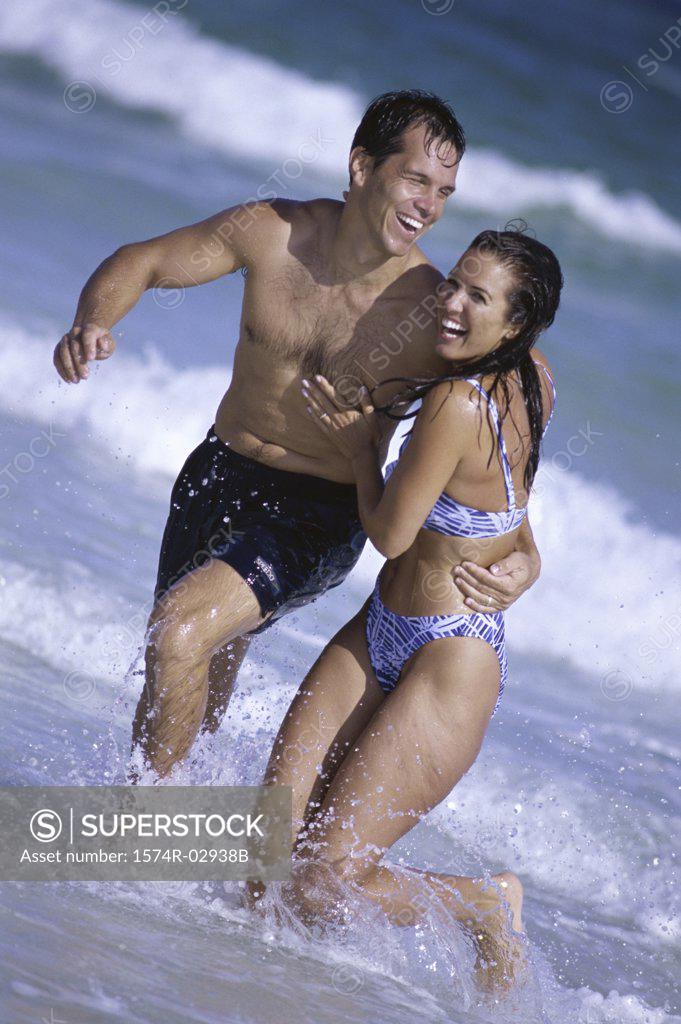 Stock Photo: 1574R-02938B Young couple running on the beach