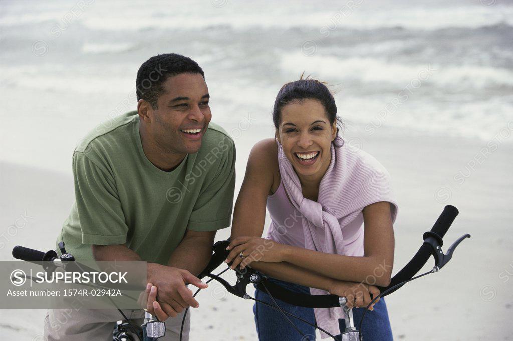 Stock Photo: 1574R-02942A Young couple with bicycles on the beach