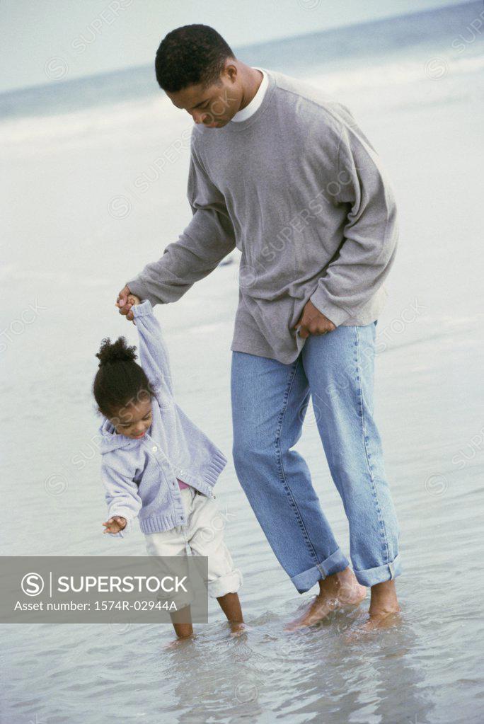 Stock Photo: 1574R-02944A Father walking with his daughter on the beach