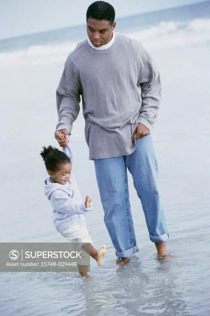 Father walking with his daughter on the beach