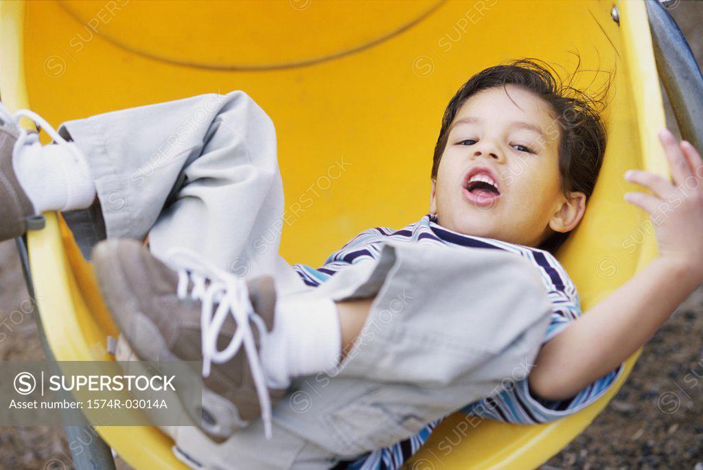 Stock Photo: 1574R-03014A Portrait of a boy lying on a slide