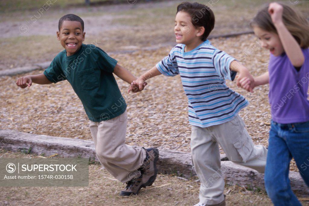Stock Photo: 1574R-03015B Two boys and a girl running holding hands