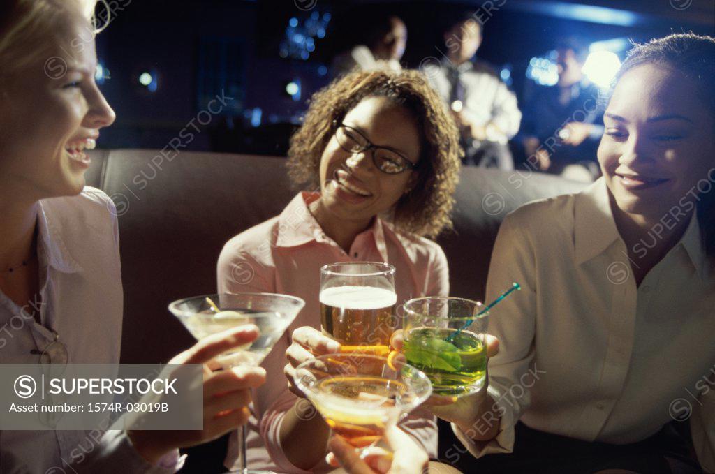 Stock Photo: 1574R-03019B Close-up of three young women toasting with glasses