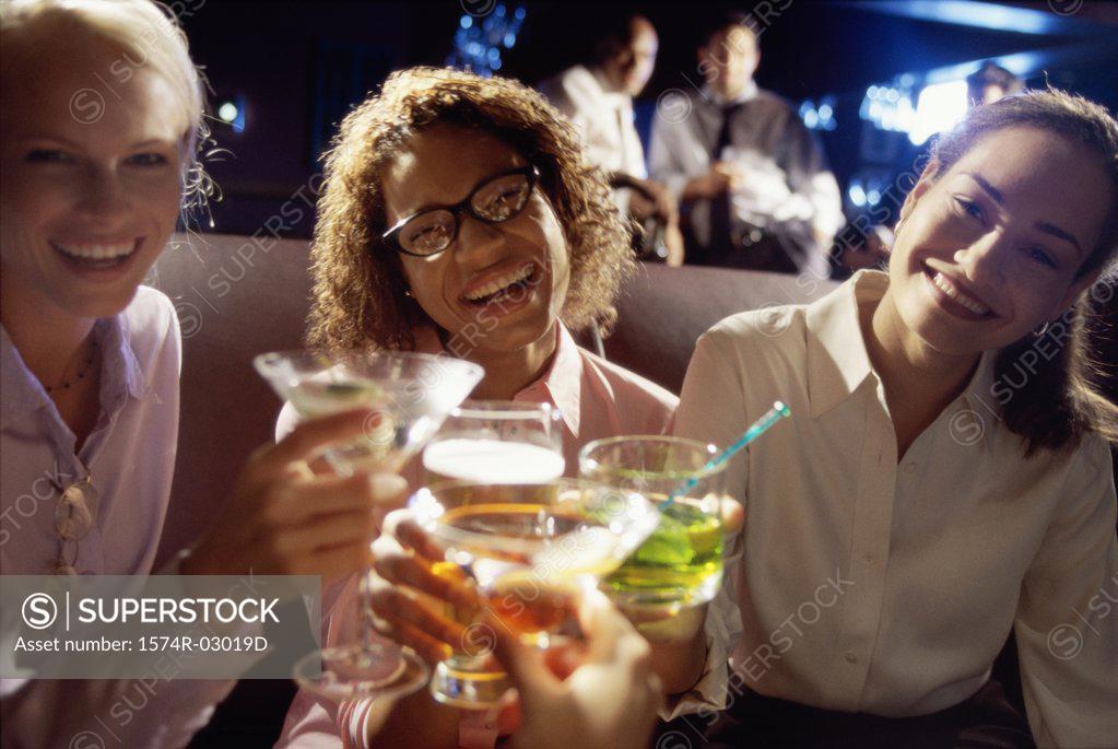 Stock Photo: 1574R-03019D Close-up of three young women toasting with glasses
