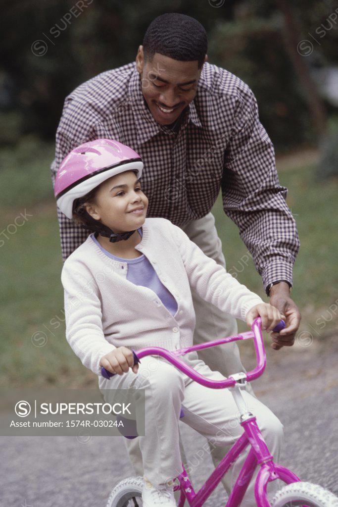 Stock Photo: 1574R-03024A Father teaching his daughter cycling