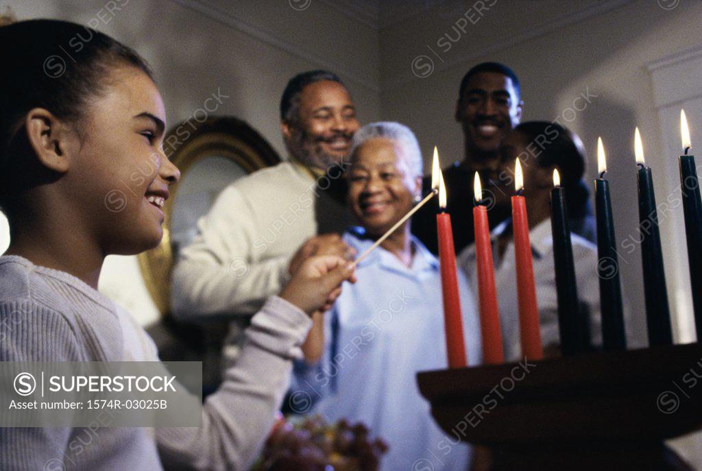 Stock Photo: 1574R-03025B Girl lighting candles to celebrate Kwanzaa