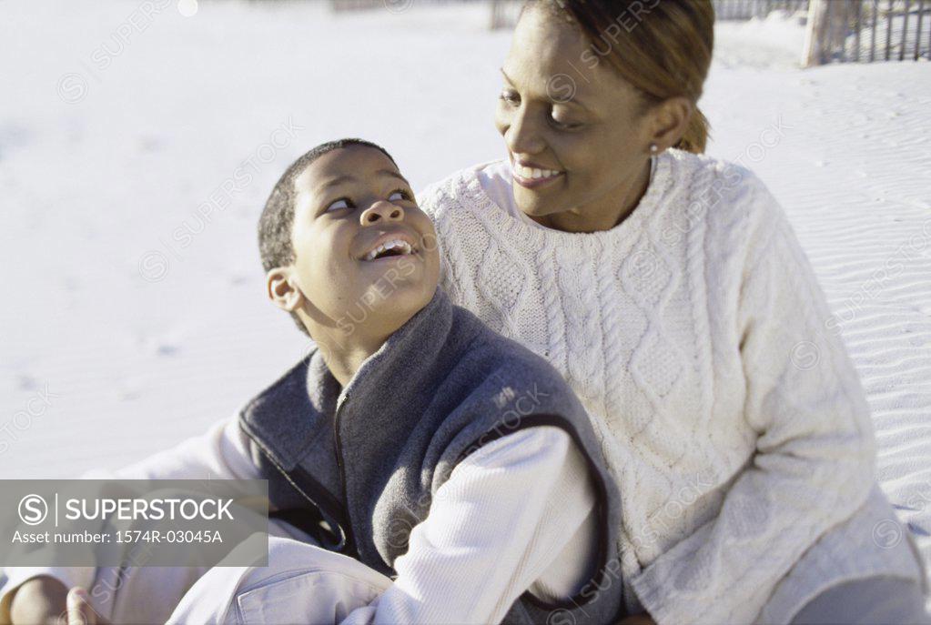 Stock Photo: 1574R-03045A Mother sitting with her son on the beach