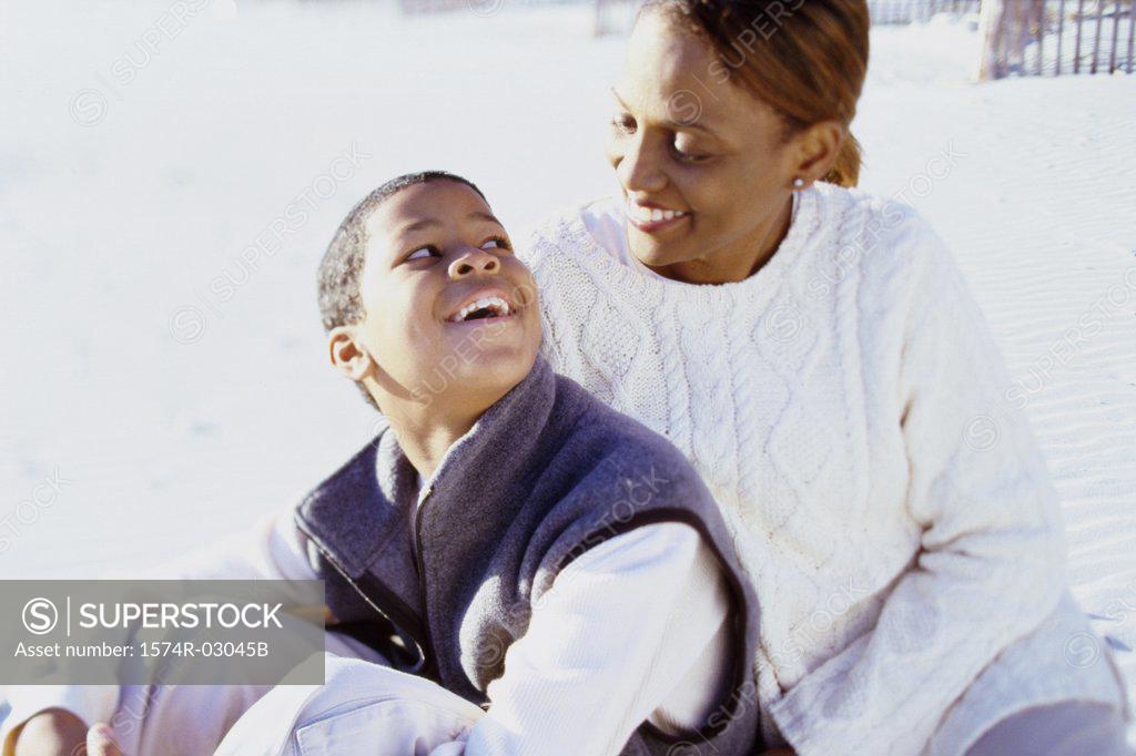 Stock Photo: 1574R-03045B Mother sitting with her son on the beach