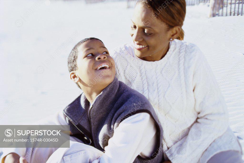 Stock Photo: 1574R-03045D Mother sitting with her son on the beach