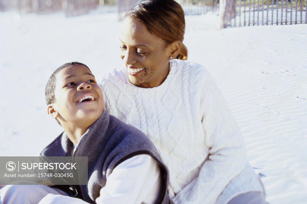 Stock Photo: 1574R-03045G Mother sitting with her son on the beach